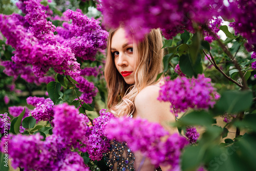 beautiful young happy girl in an incredible dress resting outdoors,woman walking in the park amid blooming lilacs © Pavel