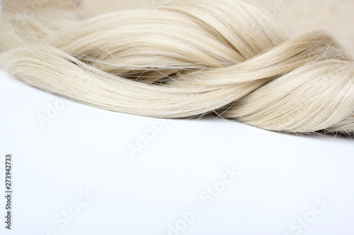 Beautiful wavy hair. Light brown hair. Hair is gathered in a bun on a white background. With free space for text. For a poster or business card.