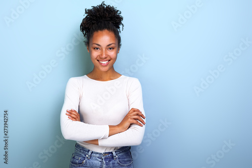 Foto Happy african american woman folded arms while standing over studio blue backgro