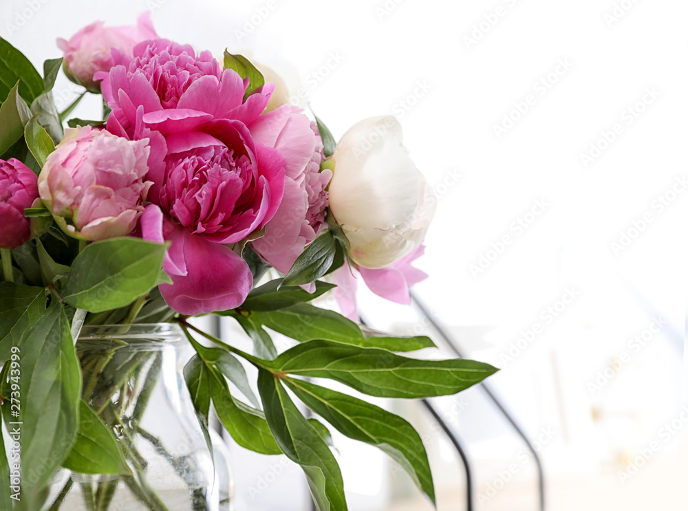 Fototapeta premium Vase with bouquet of beautiful peonies near white wall, space for text
