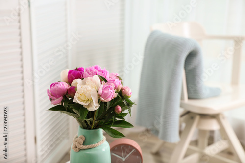 Vase with bouquet of beautiful peonies in room. Space for text © New Africa