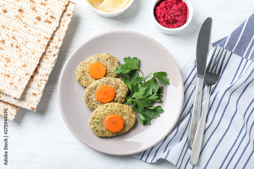 Flat lay composition with plate of traditional Passover (Pesach) gefilte fish on wooden background