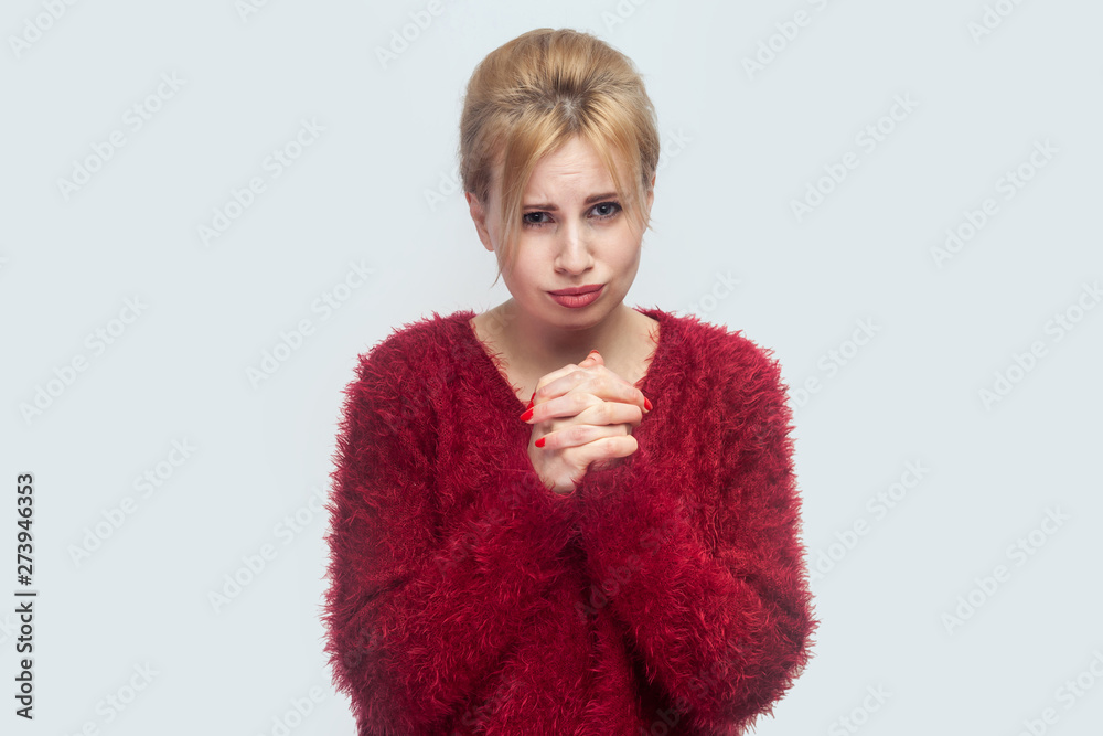 Please forgive me, or help. Portrait of sorry hopeful beautiful young blond woman in red blouse standing and begging or asking for something. indoor studio shot isolated on light gray background. Please forgive me, or help. Portrait of sorry hopeful beautiful young blond woman in red blouse standing and begging or asking for something. indoor studio shot isolated on light gray background.