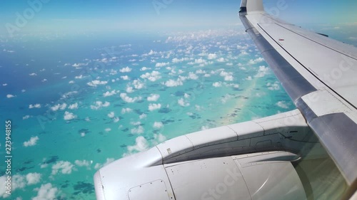 wing and engine of an airplane flying over bahamas