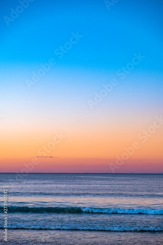 Fototapeta Naklejka Na Ścianę i Meble -  A beautiful sunset afternoon at Noosa beach overlooking the ocean and golden sky