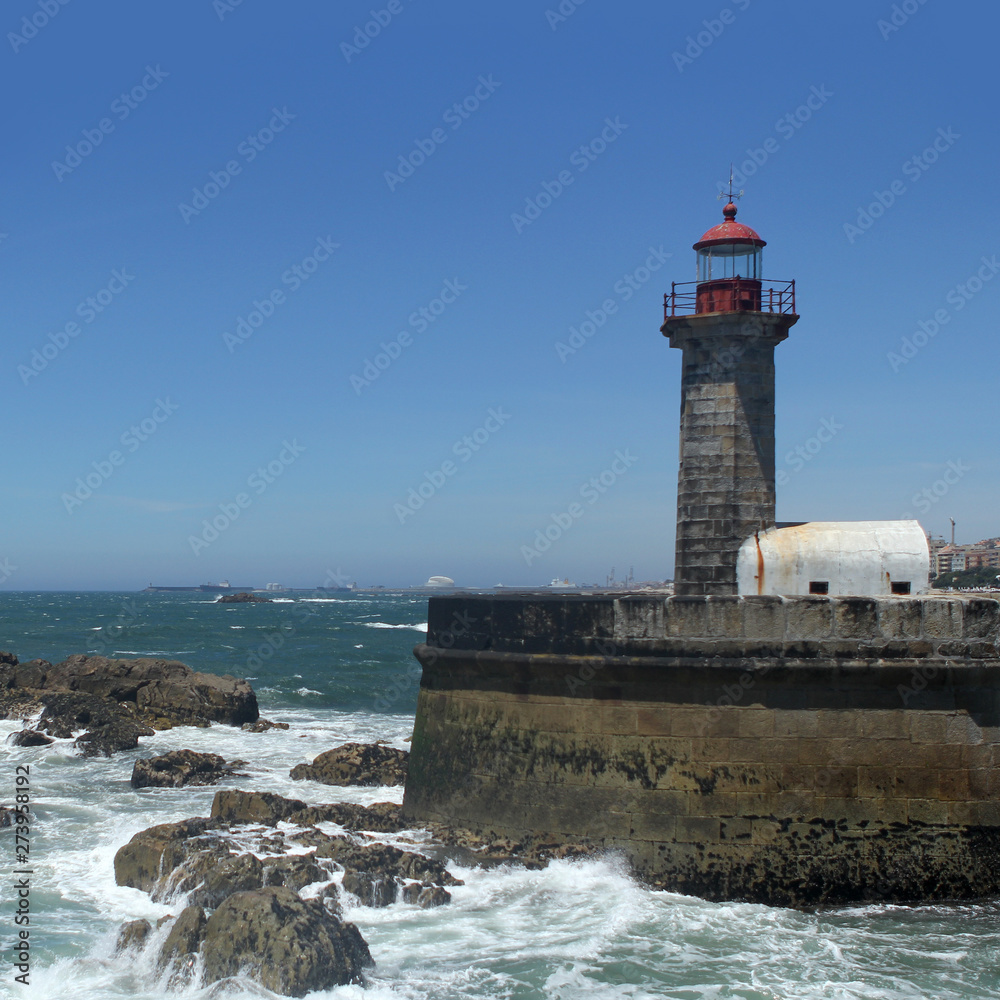 beautiful strict lighthouse on the shore of the blue atlantic ocean in portugal, square