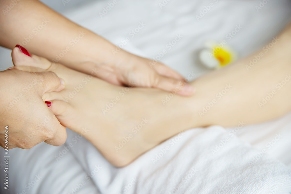 Woman receiving foot massage service from masseuse close up at hand and foot - relax in foot massage therapy service concept Woman receiving foot massage service from masseuse close up at hand and foot - relax in foot massage therapy service concept