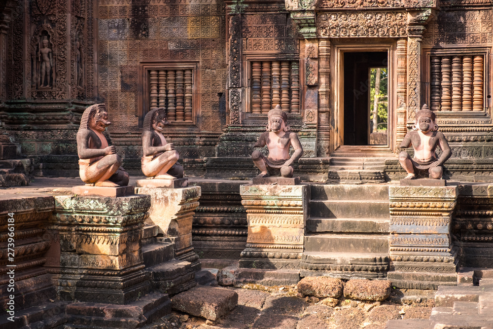 Fototapeta premium The ancient guardian statue in Banteay Srei a 10th-century Cambodian temple dedicated to the Hindu god Shiva made by pink/red sandstone in Siem Reap, Cambodia.
