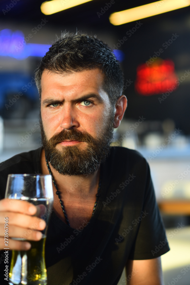 Portrait of handsome young man tasting a draft beer. Handsome barman holding a pint of beer. Man holds glass of beer.