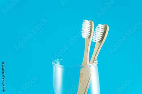 Close up wooden toothbrush in glass with blue background  selective focus