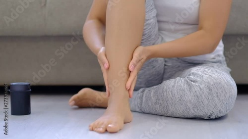 slow motion. Woman rubbing tired swollen feet, varicose veins. Female doing foot massage at home after a hard day.