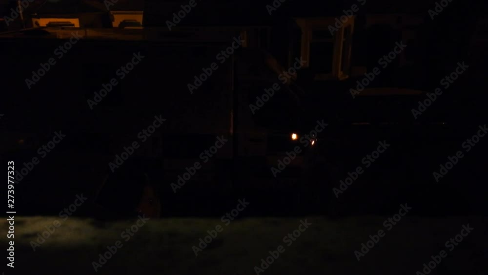 An ambient bedroom window night shot of an ambulance siren parked on a typical British street