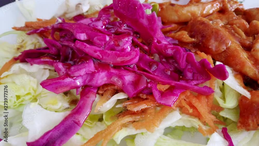 Close view of hand pouring sauce salad on table Close view of hand pouring sauce salad on table