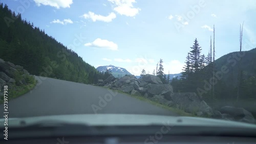 a back road in Washington state in Snoqualmie pass. just a basic shot of a car driving on a tree covered road. photo