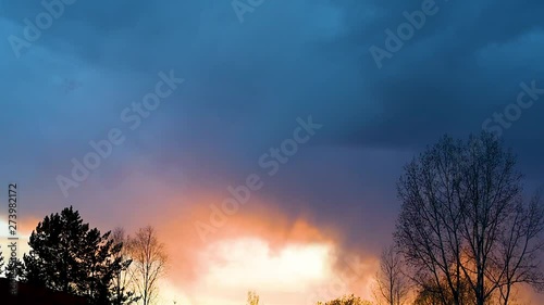 Bright sunset or sunrise on a dark sky with thunderclouds. Sunset or sunrise with dark clouds and sunlight , against the light  photo