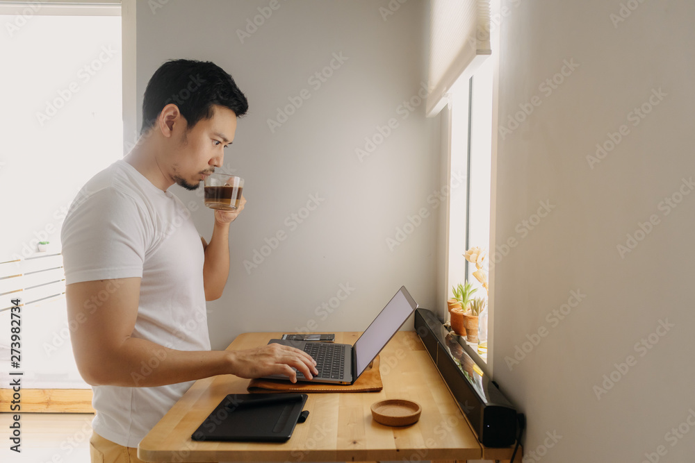 Freelancer man is working on his laptop in his apartment. Concept of freelance creative works.