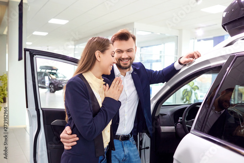 A young couple chooses a car and auto salon