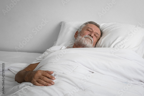 senior man sleeping alone on bed in room