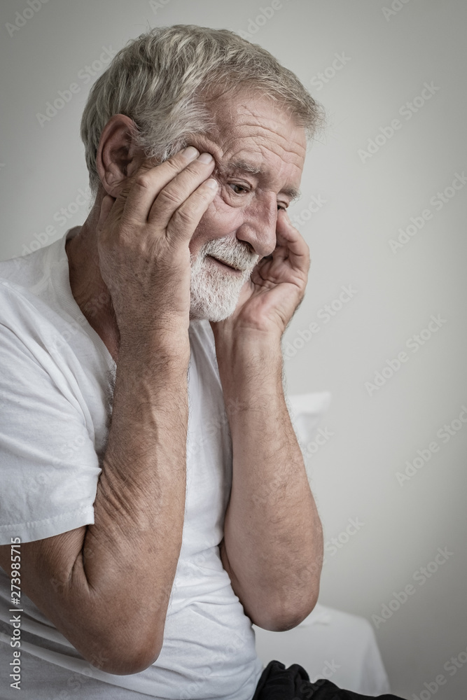 senior man thinking or try to remember alone on bed in white room senior man thinking or try to remember alone on bed in white room