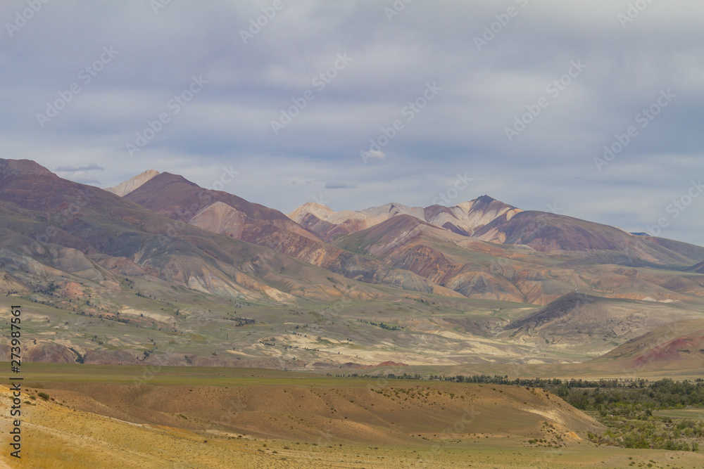 Red mountains in Kyzyl-Chin valley in Altay. Scenic landscape with clouds. Summer concept.