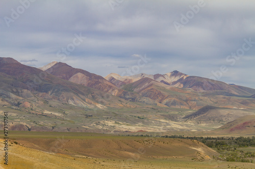 Red mountains in Kyzyl-Chin valley in Altay. Scenic landscape with clouds. Summer concept.