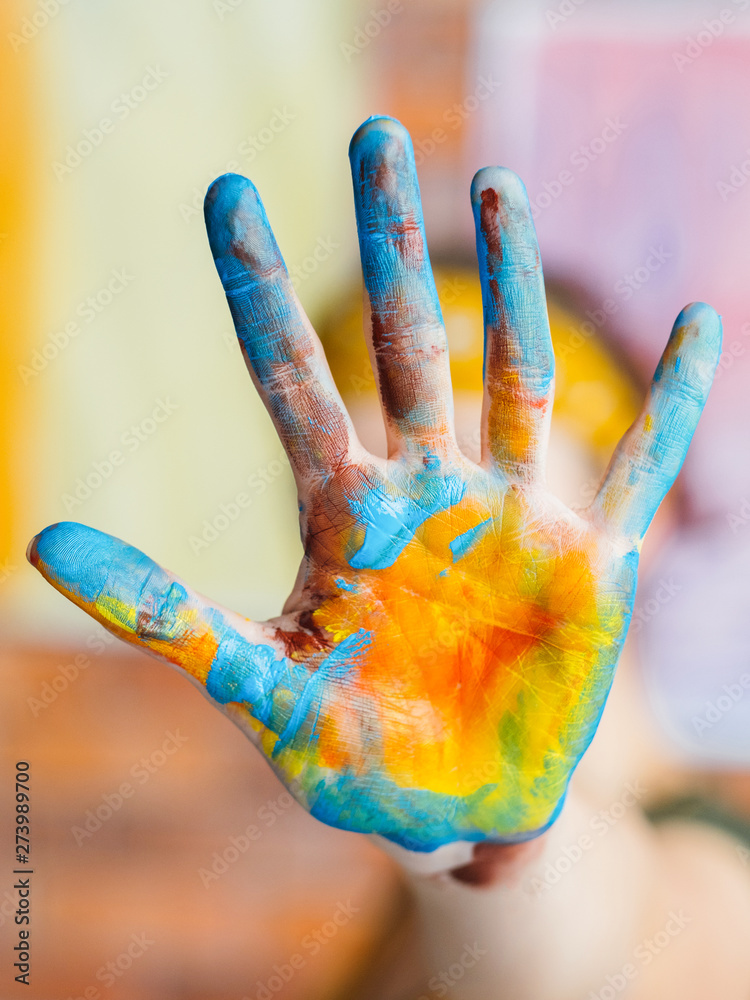 Finger painting art trend. Closeup of blue and yellow colored hand. Blur  background. Stock Photo | Adobe Stock