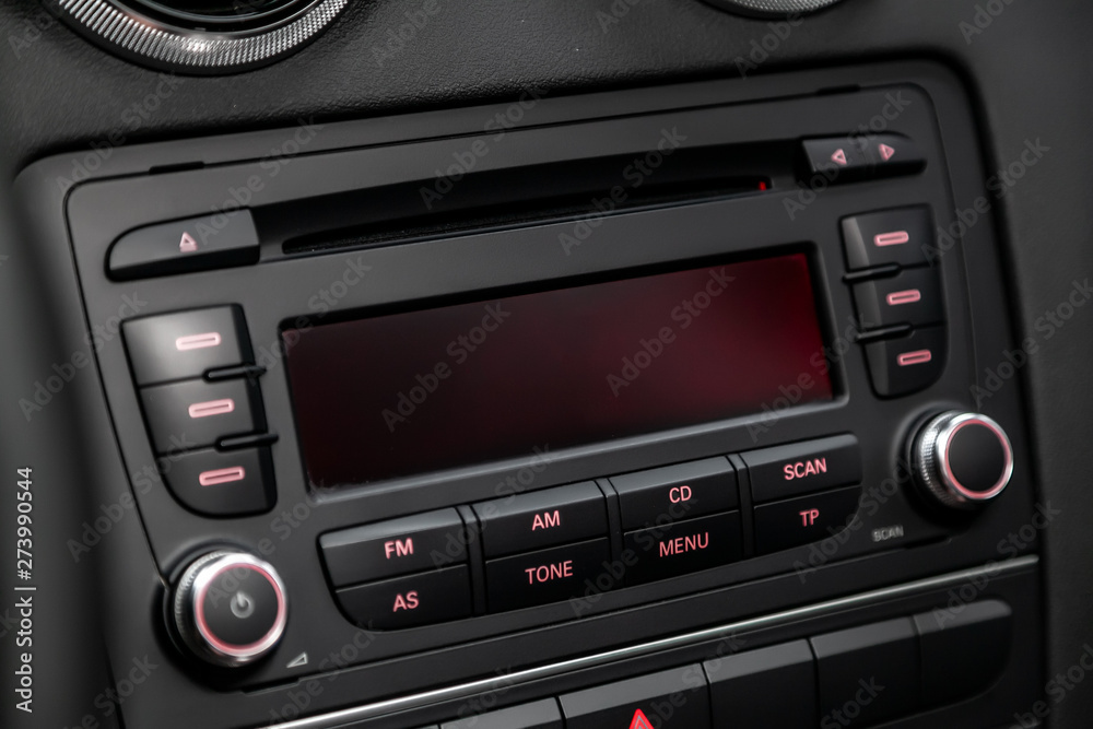 .A shallow depth of field close up of the control panel of a car. Parts shown are the CD player and radio controller, as well as the air conditioning control dials