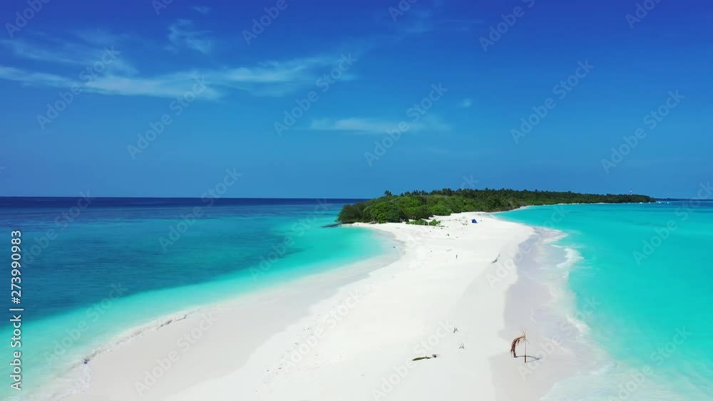 Aerial view of a beach at a tropical island in turquoise water in the Caribbean Sea. Dolly out.