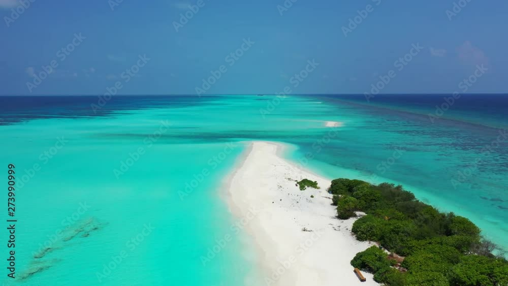 Flying above a tropical island in a strip of turquoise water surrounded by blue water. Revealing tropical trees. In The Caribbean. Dolly out. Flying above a tropical island in a strip of turquoise water surrounded by blue water. Revealing tropical trees. In The Caribbean. Dolly out.