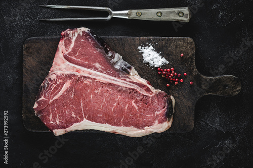 T-bone Steak Raw Dry Aged Beef on Vintage Cutting Board photo