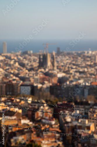 Focused barbed wire with the city of Barcelona blurred in background © Gabriel