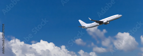 Commercial passenger aircraft in white colour. Blue cloudy sky in the background photo