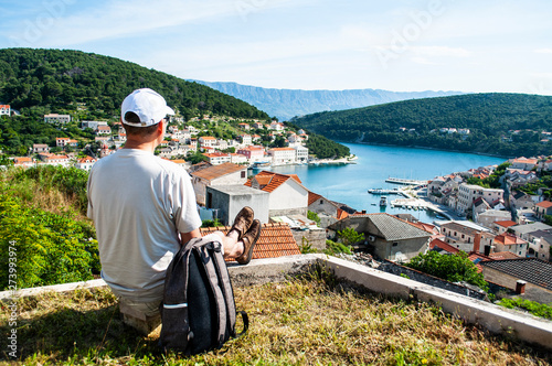 man with  backpack on  mountain, the view of  sea and the European old town, Croatia, the view from the top of the bay, the concept of tourism and travel.