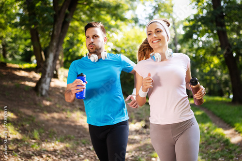 Fototapeta Naklejka Na Ścianę i Meble -  Happy couple jogging and running outdoors in nature
