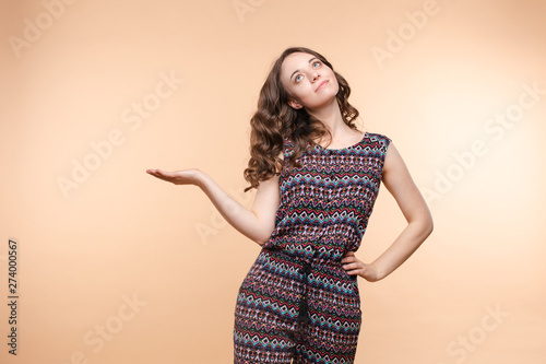 Side view studio portrait of stylish attractive young woman looking away and holding finger. Sudactive feminine model in black with make up plump lips and big eyes holding hand. Concept of style. photo