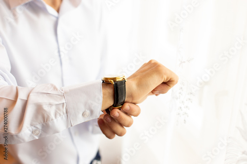 businessman checking time on his wrist watch, man putting clock on hand