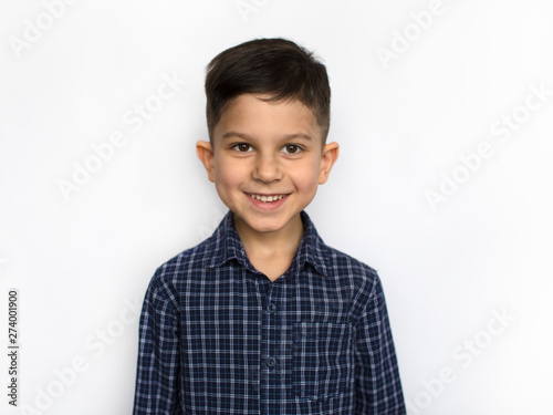Obraz na płótnie portrait of a cute little smiling boy in a blue shirt, isolated on a white background w salonie