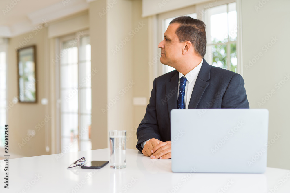 Middle age business man working with computer laptop looking to side, relax profile pose with natural face with confident smile. Middle age business man working with computer laptop looking to side, relax profile pose with natural face with confident smile.