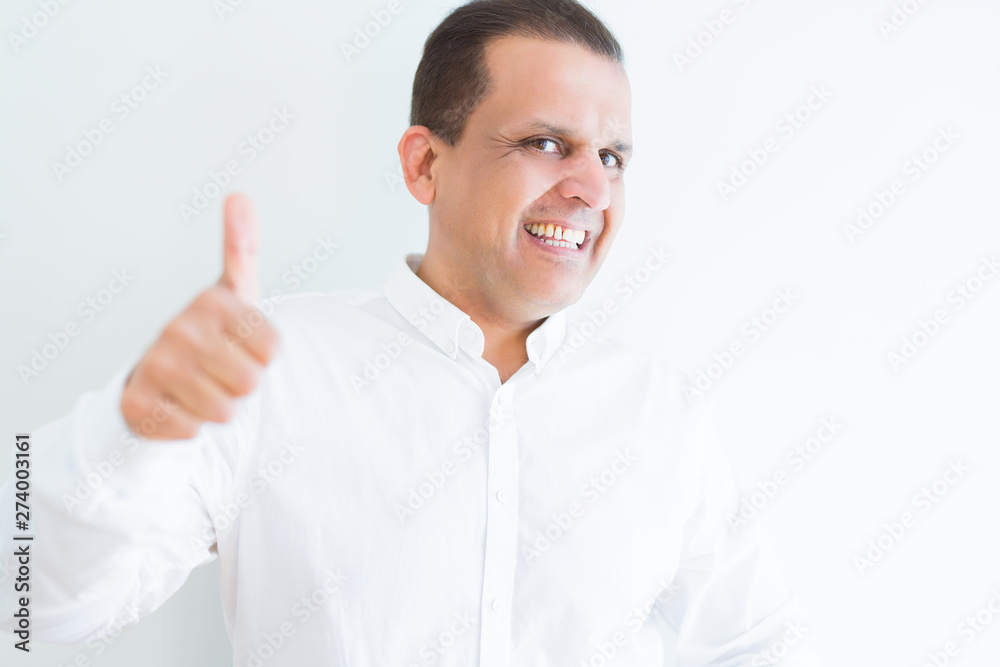 Middle age man doing postive gesture with thumbs up smiling to the camera Middle age man doing postive gesture with thumbs up smiling to the camera