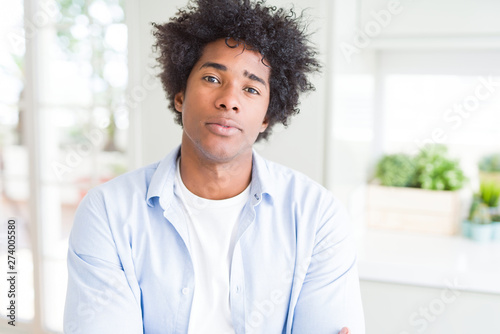 African American man at home Relaxed with serious expression on face. Simple and natural with crossed arms