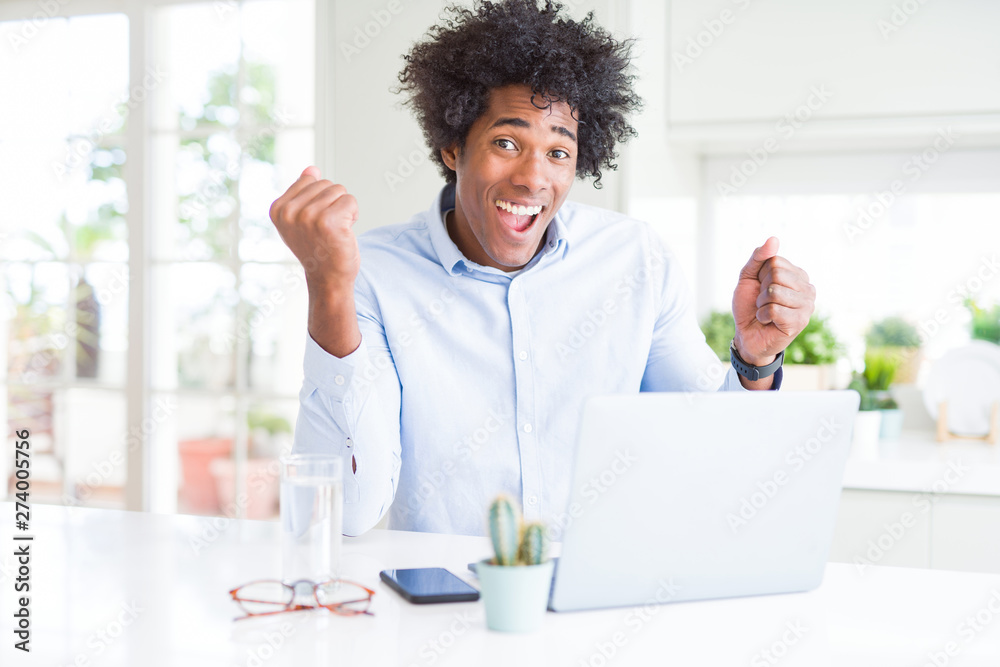 African American business man working using laptop screaming proud and celebrating victory and success very excited, cheering emotion African American business man working using laptop screaming proud and celebrating victory and success very excited, cheering emotion