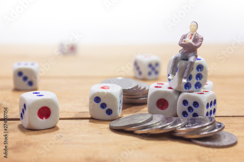 businessman sitting on dice with coins on white background. fortune investment concept.