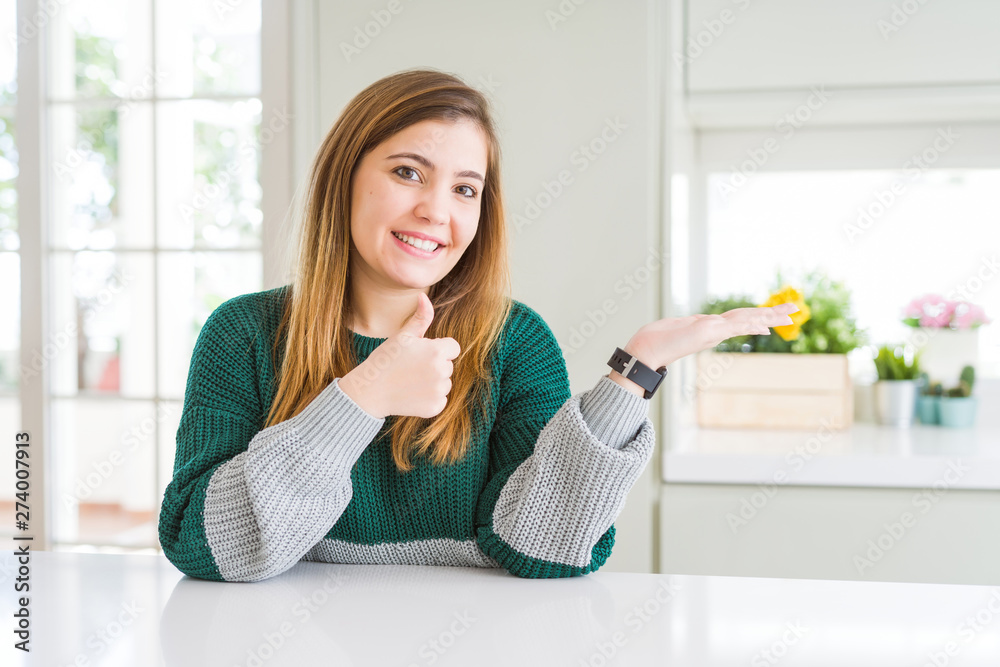 Young beautiful plus size woman wearing casual striped sweater Showing palm hand and doing ok gesture with thumbs up, smiling happy and cheerful Young beautiful plus size woman wearing casual striped sweater Showing palm hand and doing ok gesture with thumbs up, smiling happy and cheerful