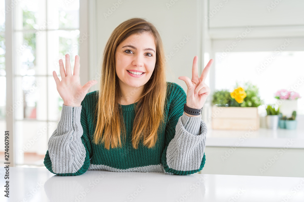 Young beautiful plus size woman wearing casual striped sweater showing and pointing up with fingers number eight while smiling confident and happy. Young beautiful plus size woman wearing casual striped sweater showing and pointing up with fingers number eight while smiling confident and happy.