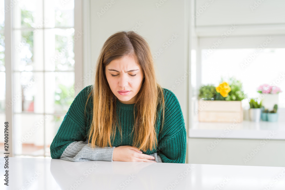 Young beautiful plus size woman wearing casual striped sweater with hand on stomach because indigestion, painful illness feeling unwell. Ache concept. Young beautiful plus size woman wearing casual striped sweater with hand on stomach because indigestion, painful illness feeling unwell. Ache concept.
