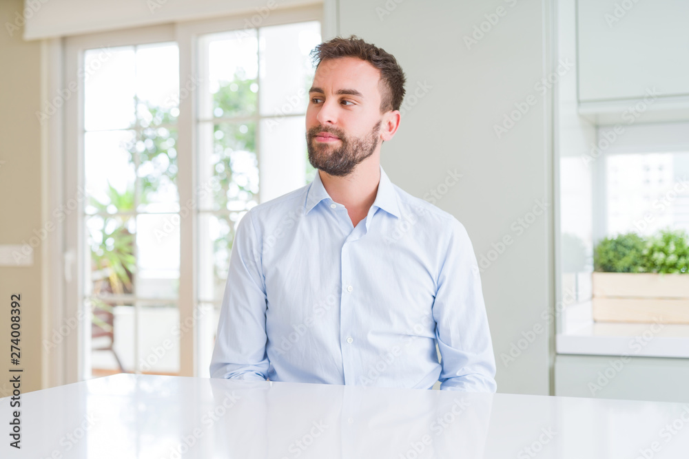 Handsome business man smiling looking side and staring away thinking.