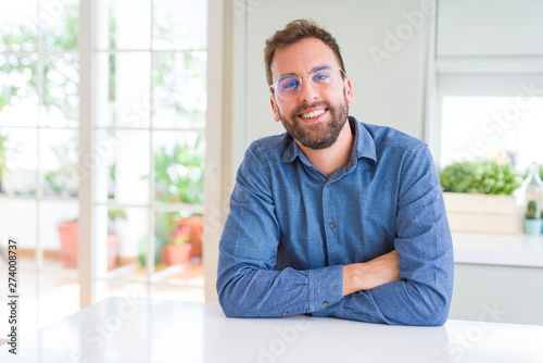 Handsome man wearing glasses and smiling relaxed at camera © Krakenimages.com