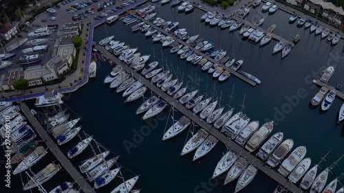 Fly over an elite yachts moored in the port eary in the morning. View from above 4k photo