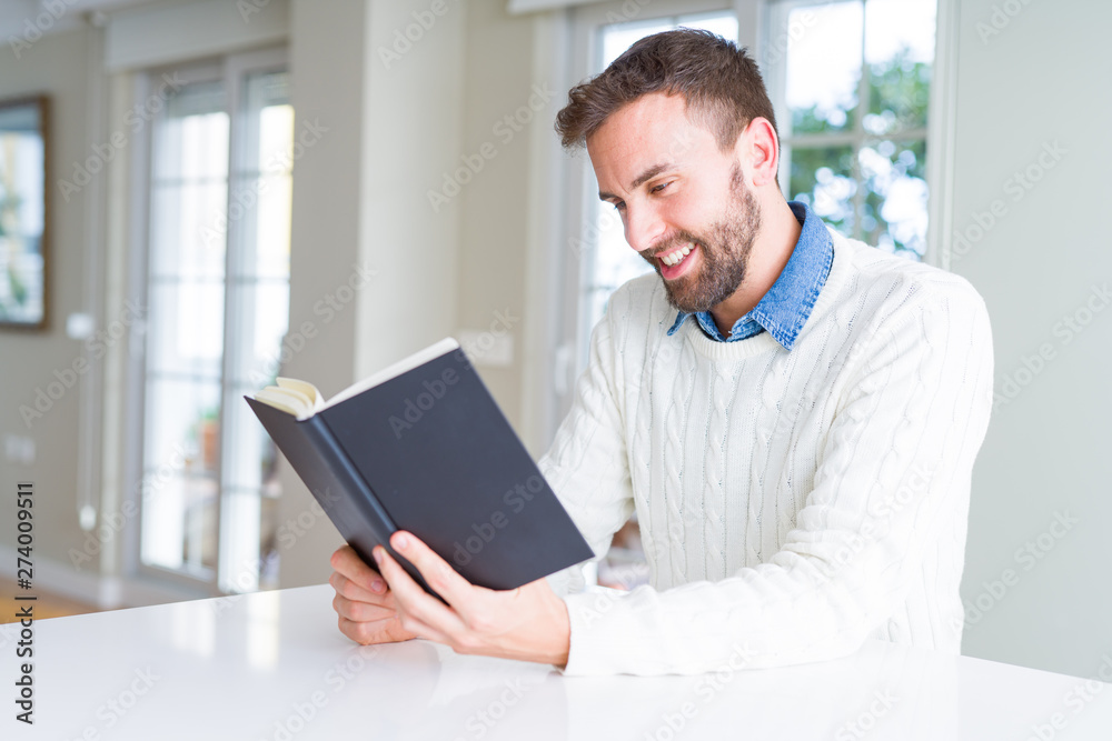 Handsome man reading a book at home Handsome man reading a book at home