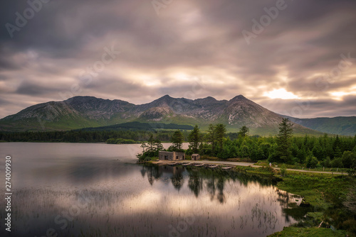 Lough Inagh in Ireland with a cabin and boats at the lake shore